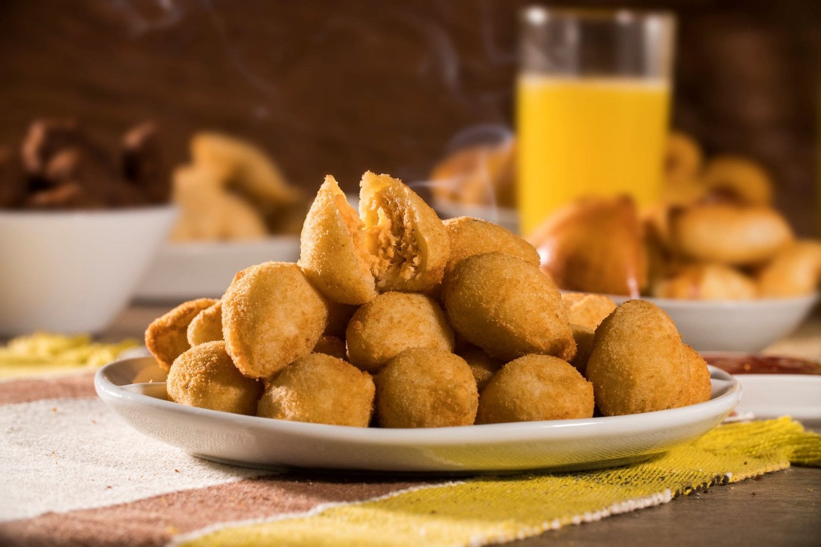 Coxinhas artesanais douradas servidas em prato com suco